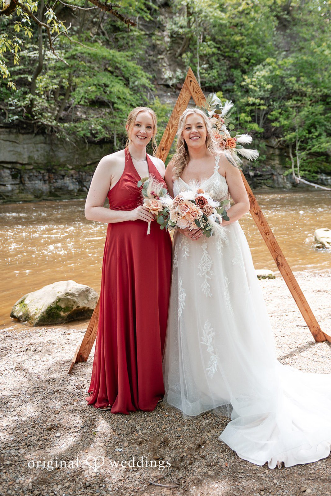 Sara + Austin Stunning portrait of bride with the bridesmaid, smiling and holding bouquets