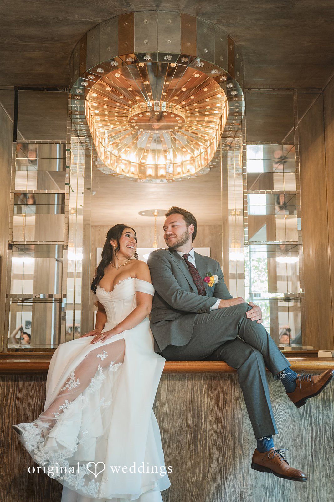 Raena + Austin A stunning portrait of the couple under the sleek beauty of the chandelier