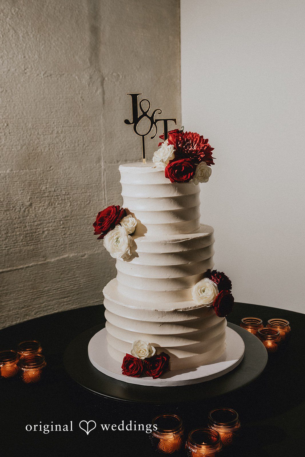 Christina + Josue An all-white wedding cake decorated with flowers