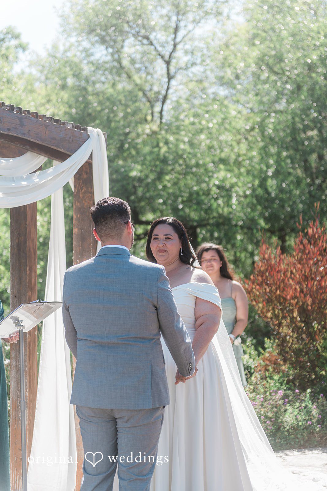 Couple looking at each other while holding hands during ceremony at Hiddenbrooke Hills captured by San Francisco Wedding Photographers from Original Weddings