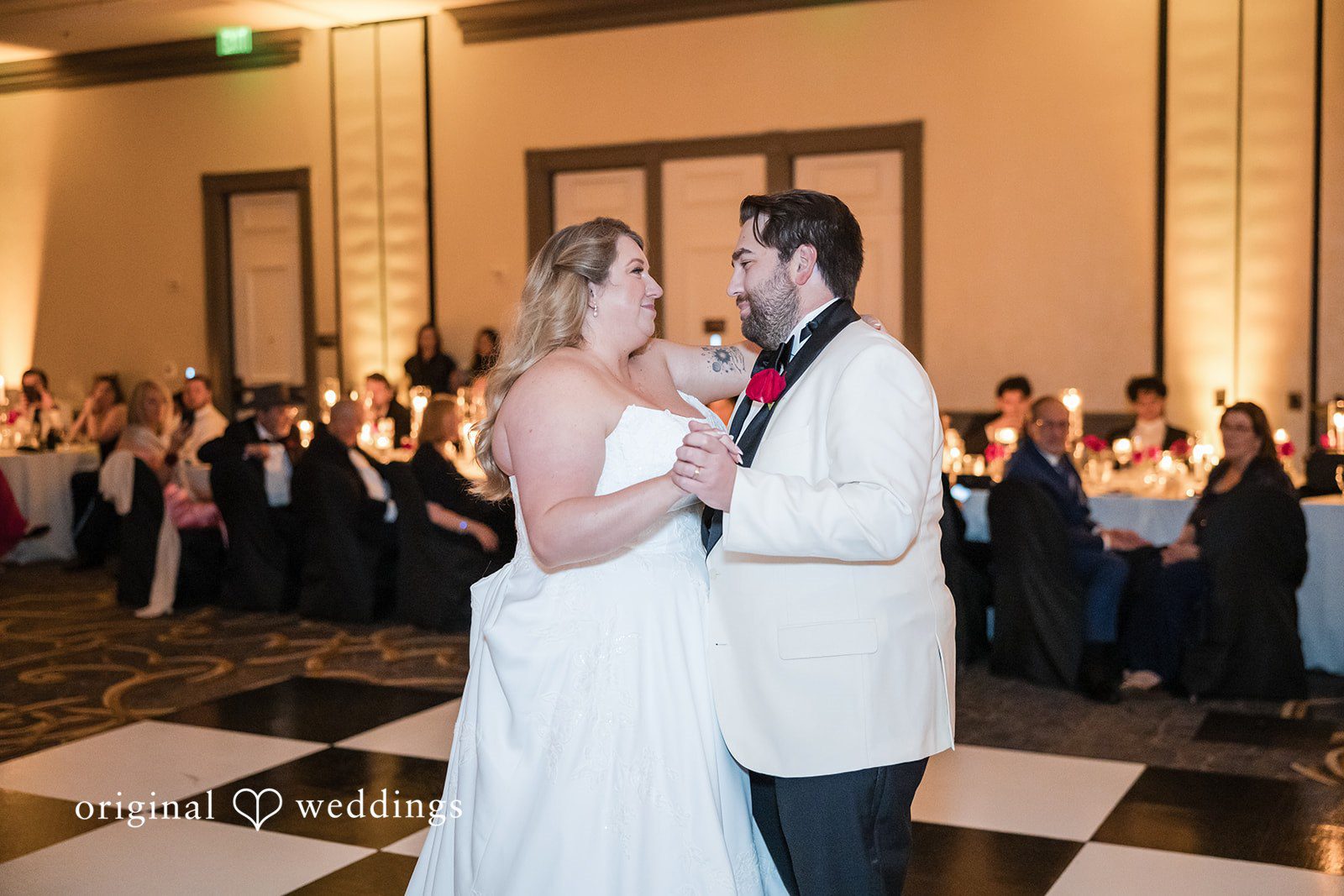 Bride and groom sharing their first dance on a dance floor.