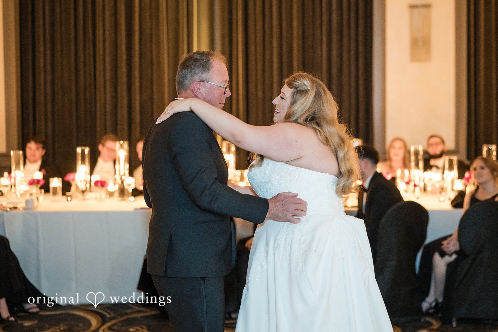 Bride dancing with a man in a dark suit on the dance floor.