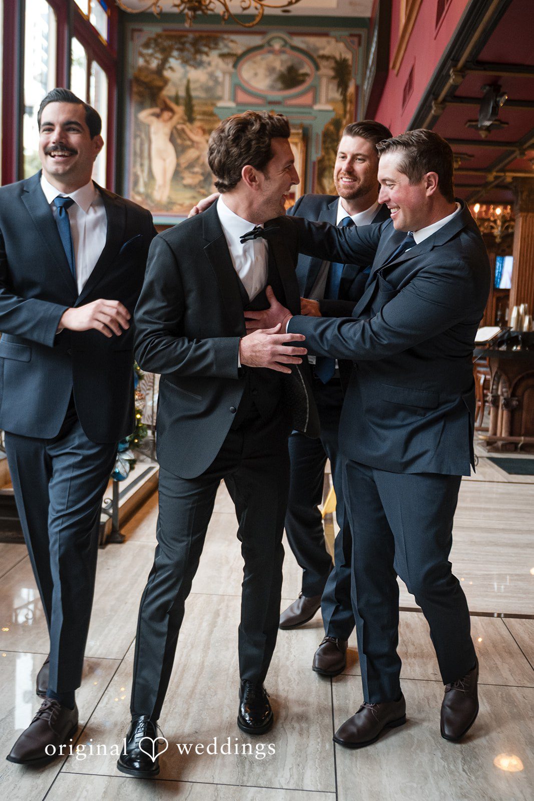 Tabatha + Justin Groom and groomsmen in suits celebrate and embrace each other.