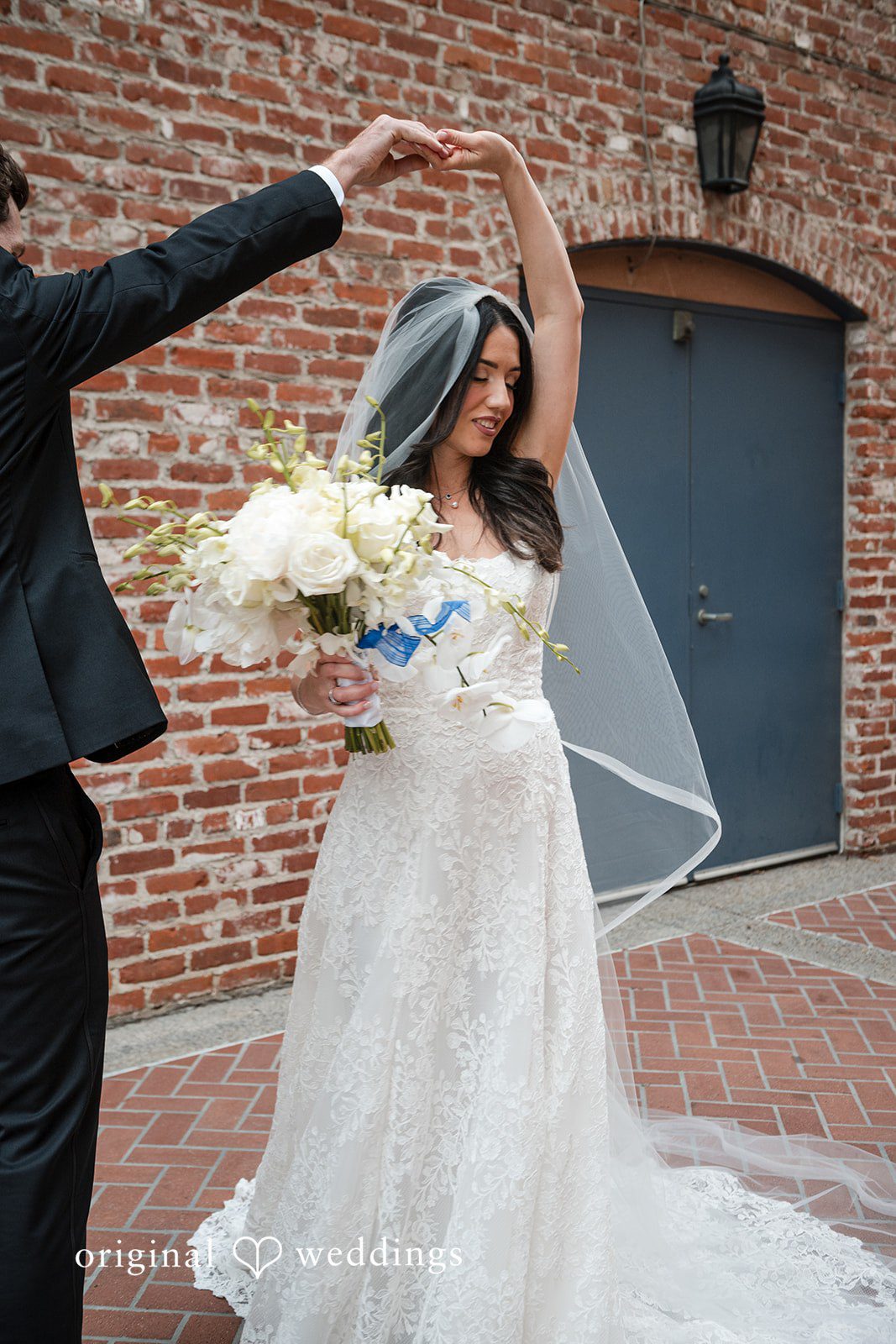 Tabatha + Justin A bride lifts her arms playfully while holding her wedding bouquet.
