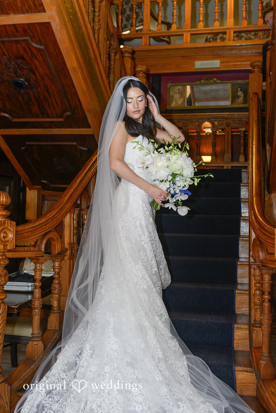 November 22, 2025 – Tabatha & Justin – (ID-4837) A bride holding a white bouquet poses on carpeted steps at Horton Grand Hotel.