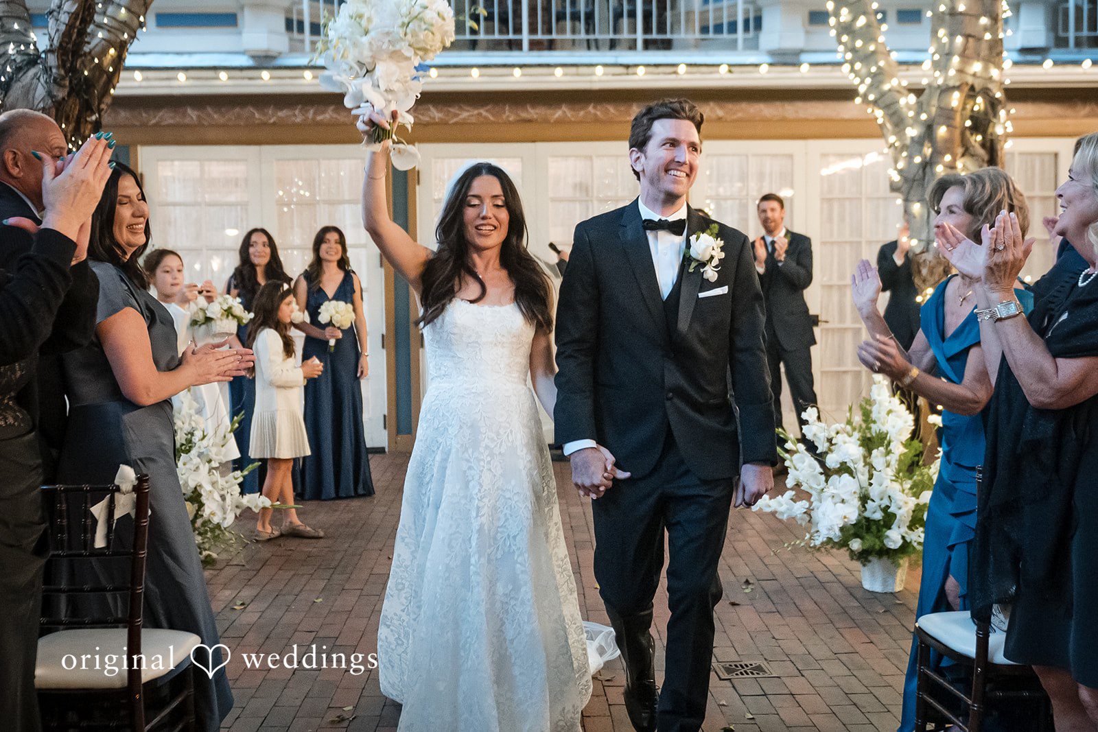 Tabatha + Justin A newlywed bride and groom smile and celebrate while walking down the aisle.