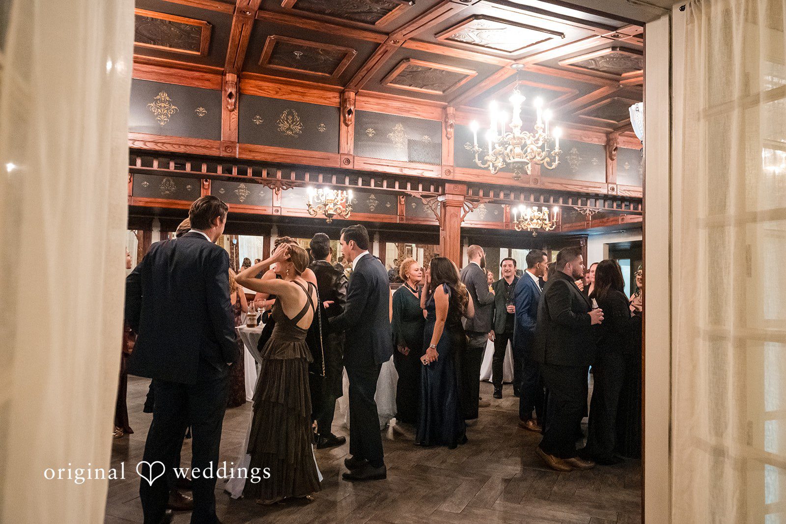 November 22, 2025 – Tabatha & Justin – (ID-4837) Wedding guests gather and mingle in a decorated reception space with chandeliers.