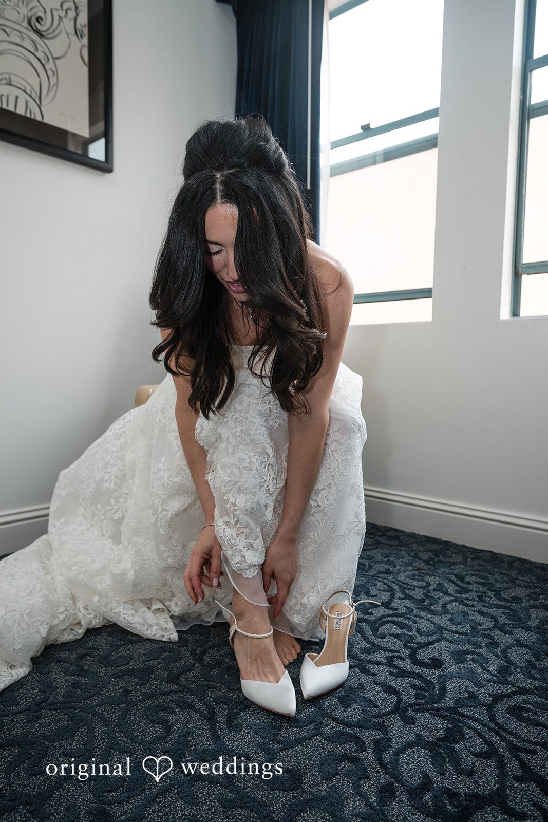 Tabatha + Justin A bride in a white wedding gown puts on her high heel shoes.