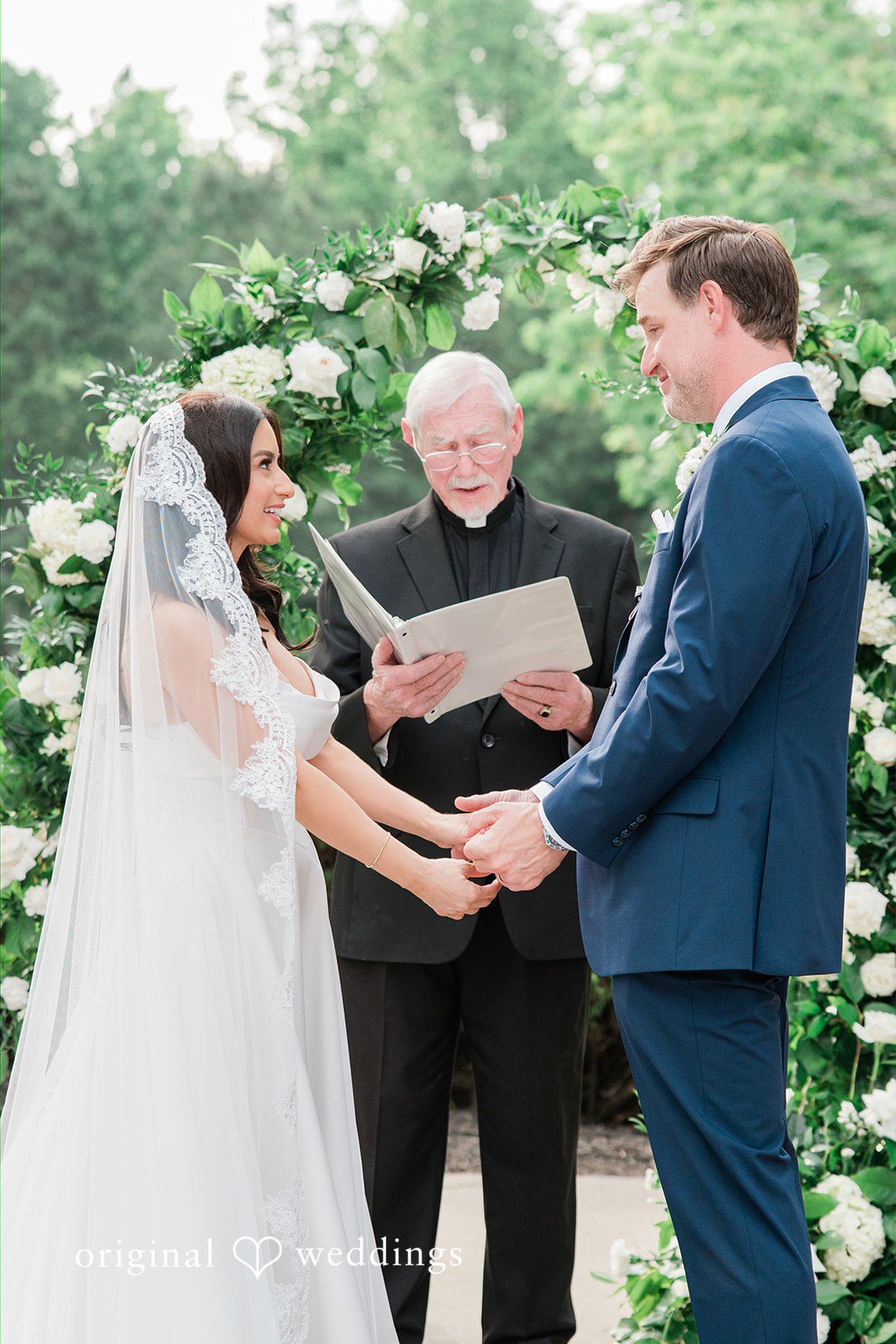 Anna + Blake Couple listening to the priest, hands in hands
