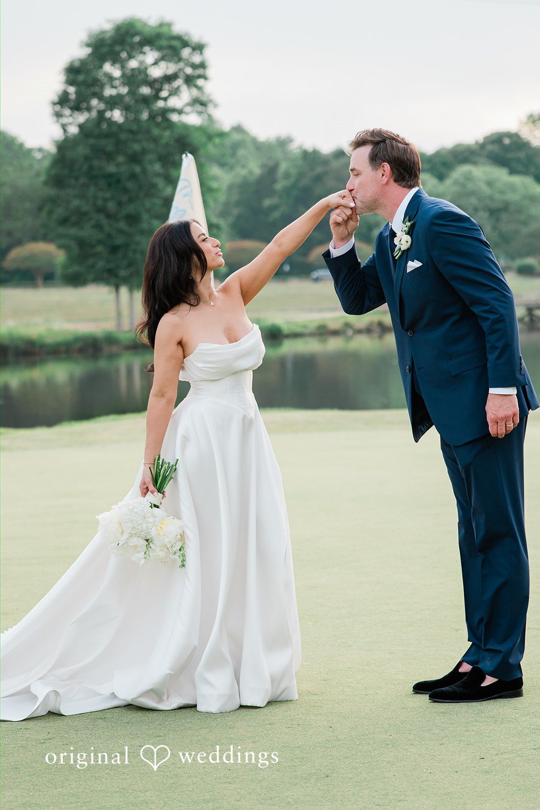 Anna + Blake Groom kissing on bride's hands during photography session