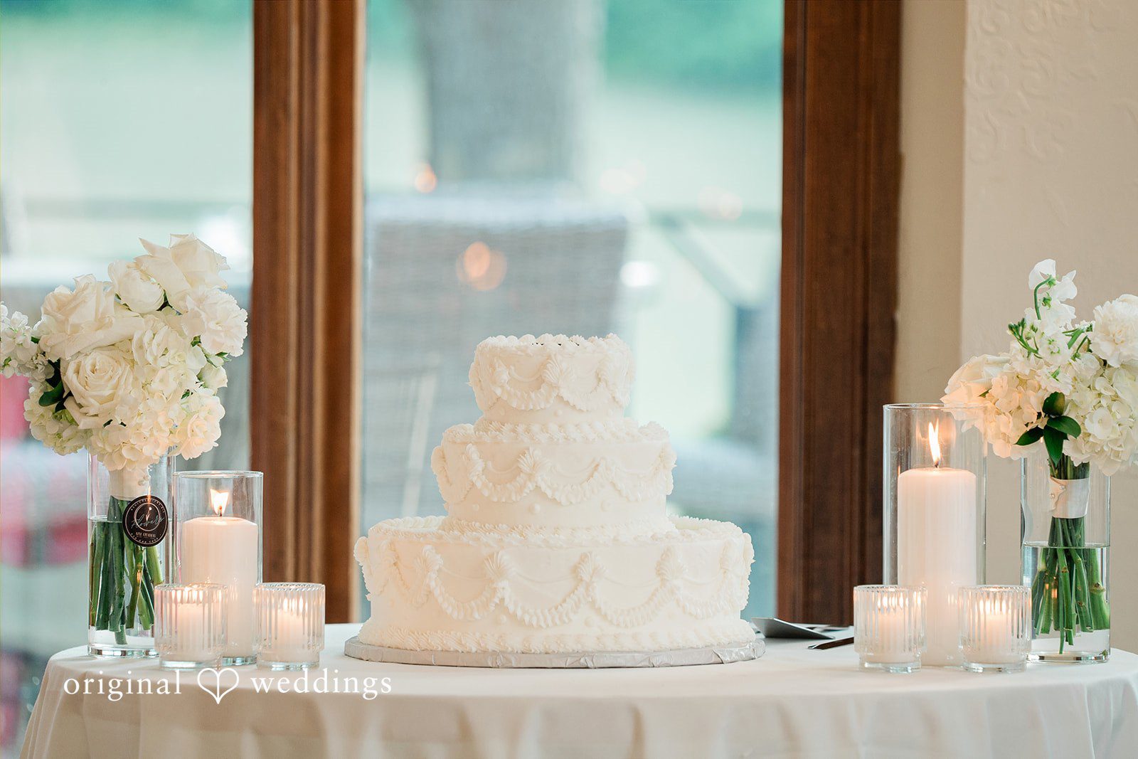 Anna + Blake Elegant wedding cake placed beautifully in between candles and flowers