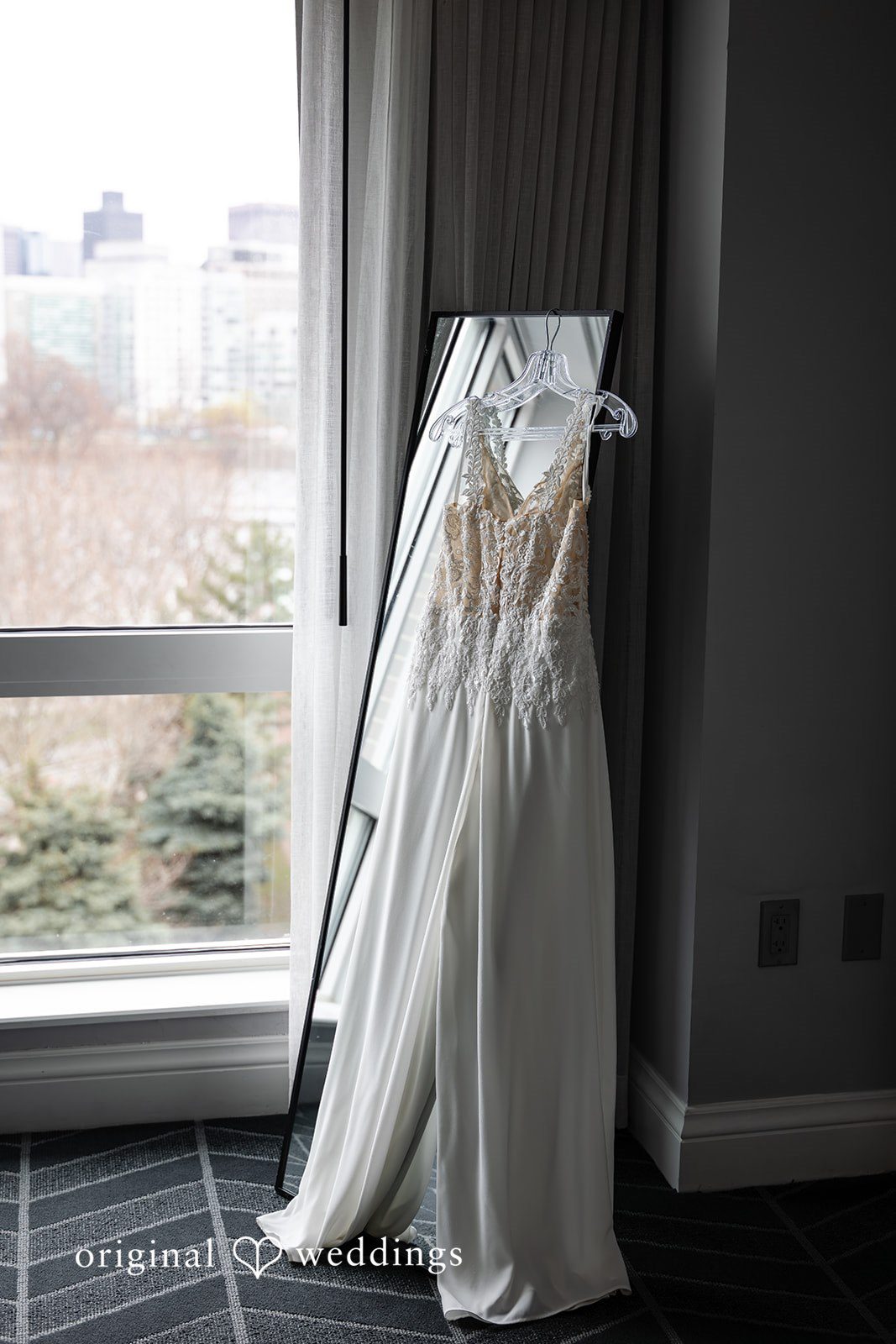 Sarah + Abby The bride's gown gracefully hung at the suite