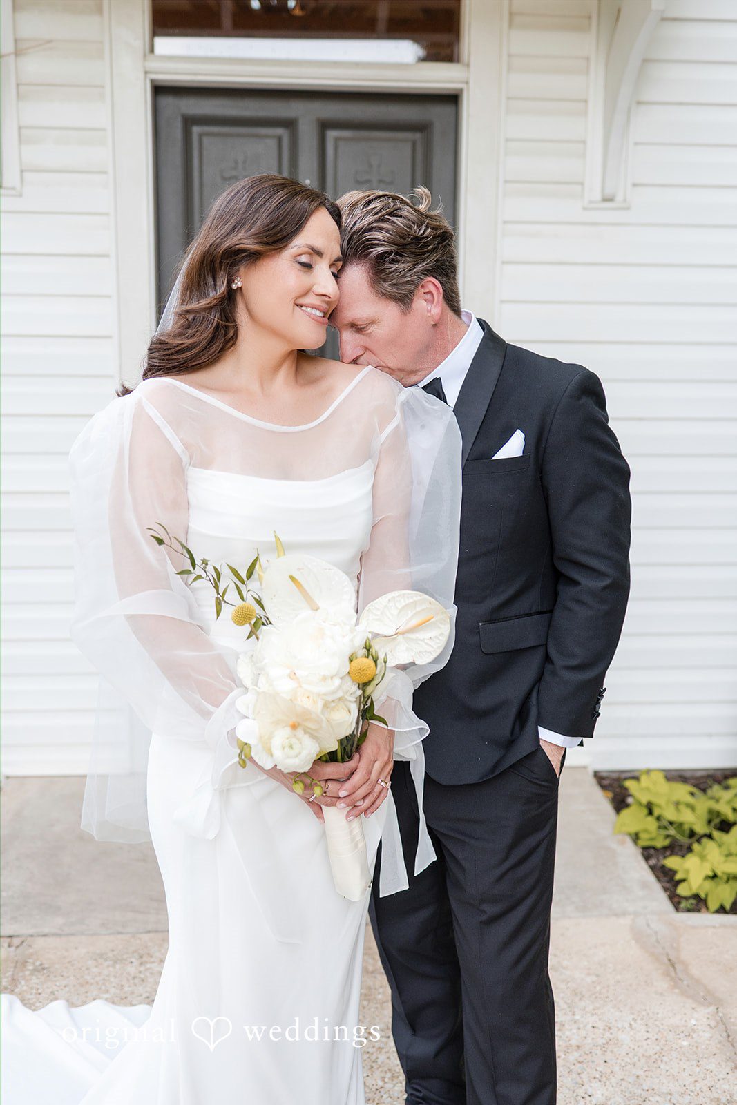 Groom kissing the bride on her shoulder