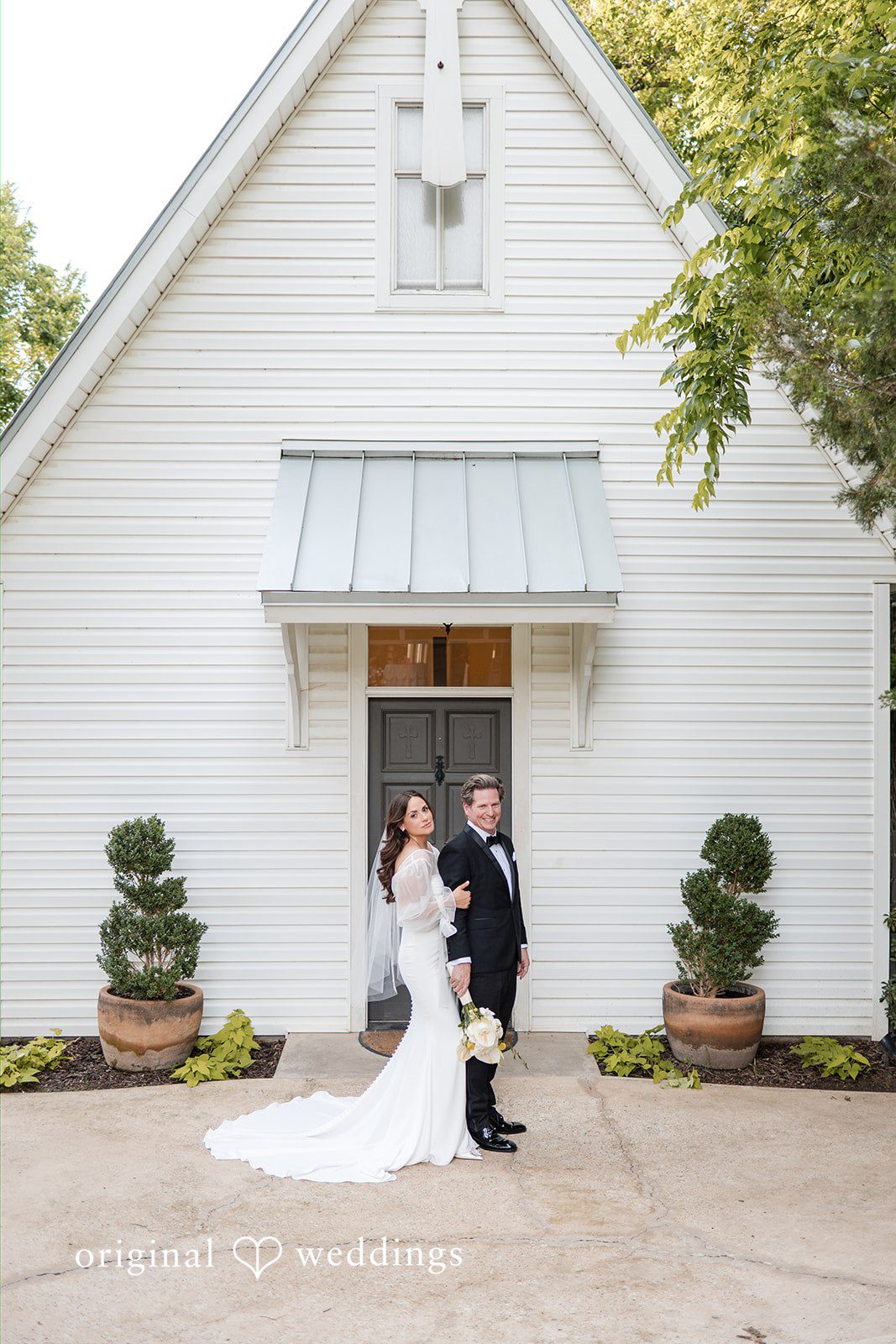 Bride hugging the groom from behind outside the venue