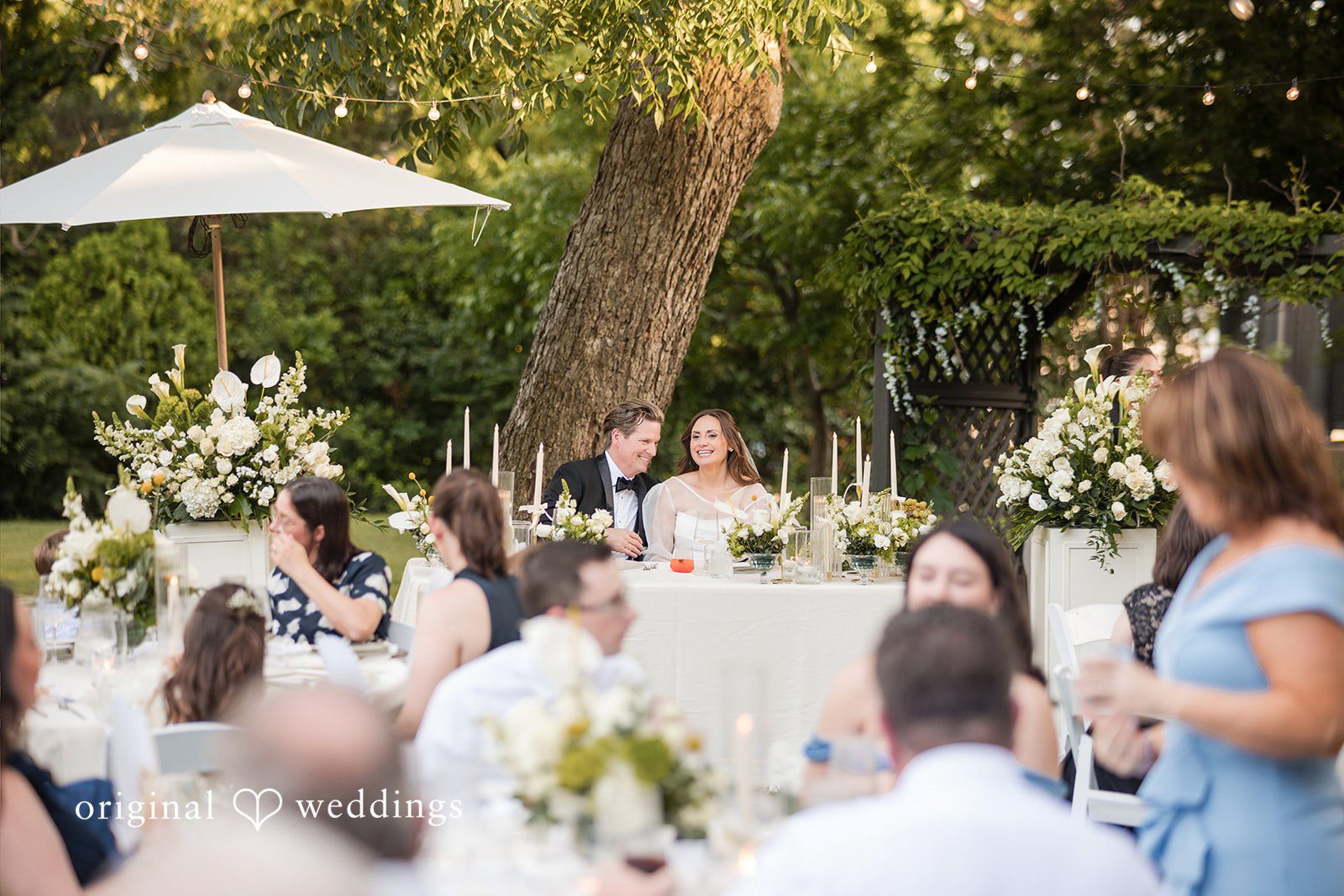 Bride and groom seated at their reception table from a distance