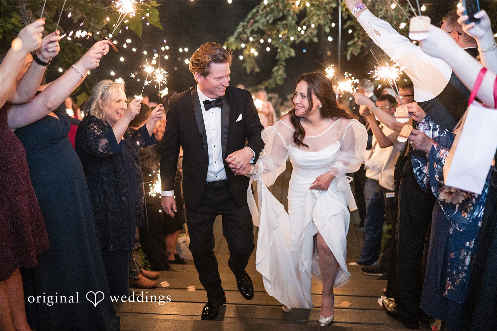 Newlyweds walking through guests during their evening celebration