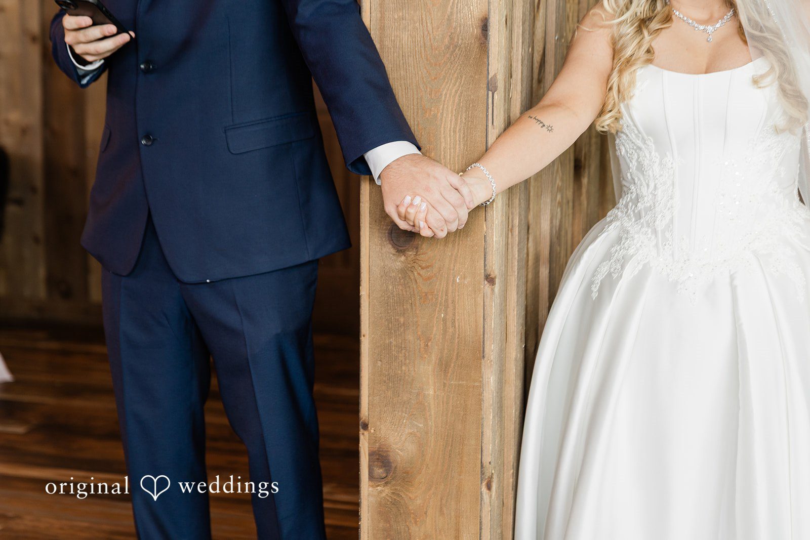 Close-up of a bride and groom holding hands at Luna's Trail Venue.