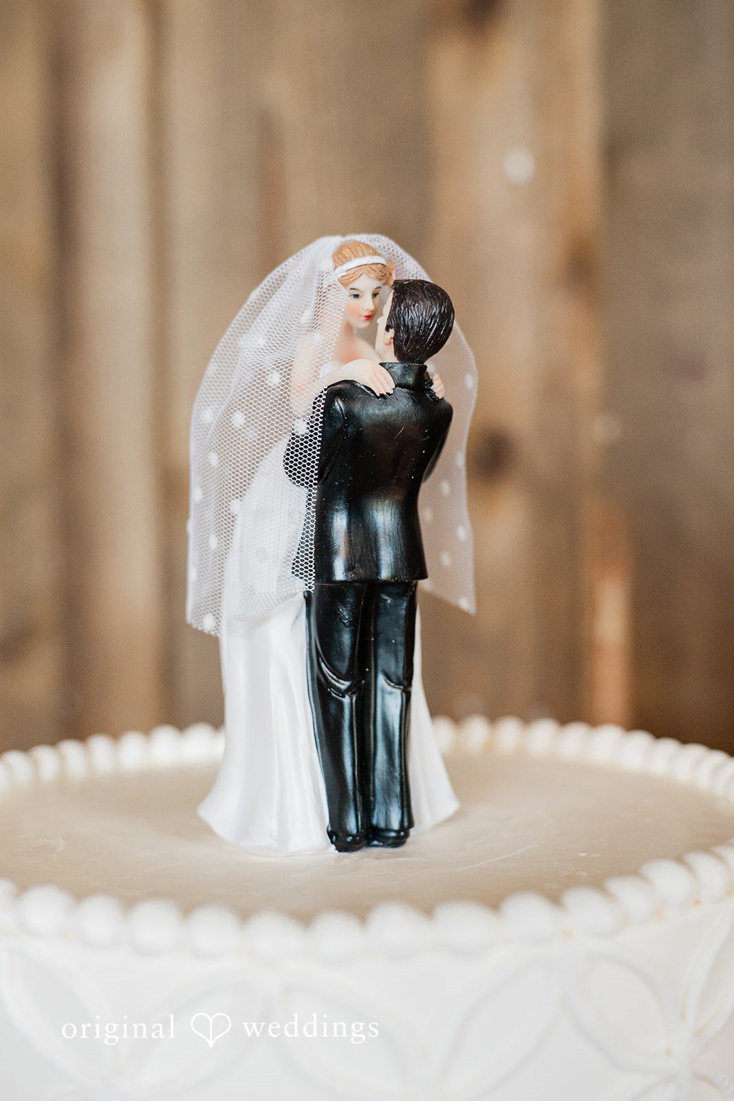 Close-up of a wedding cake topper featuring a bride and groom figurine.
