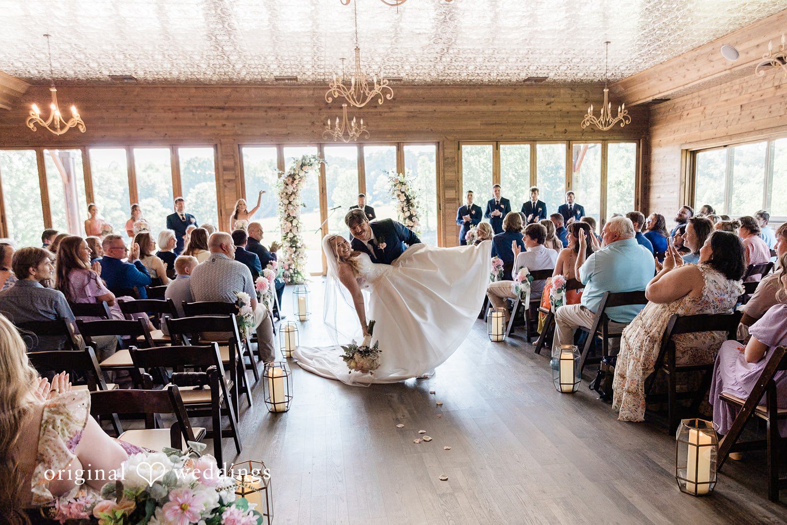 Bride and groom walking down the aisle together as husband and wife while guests applaud.