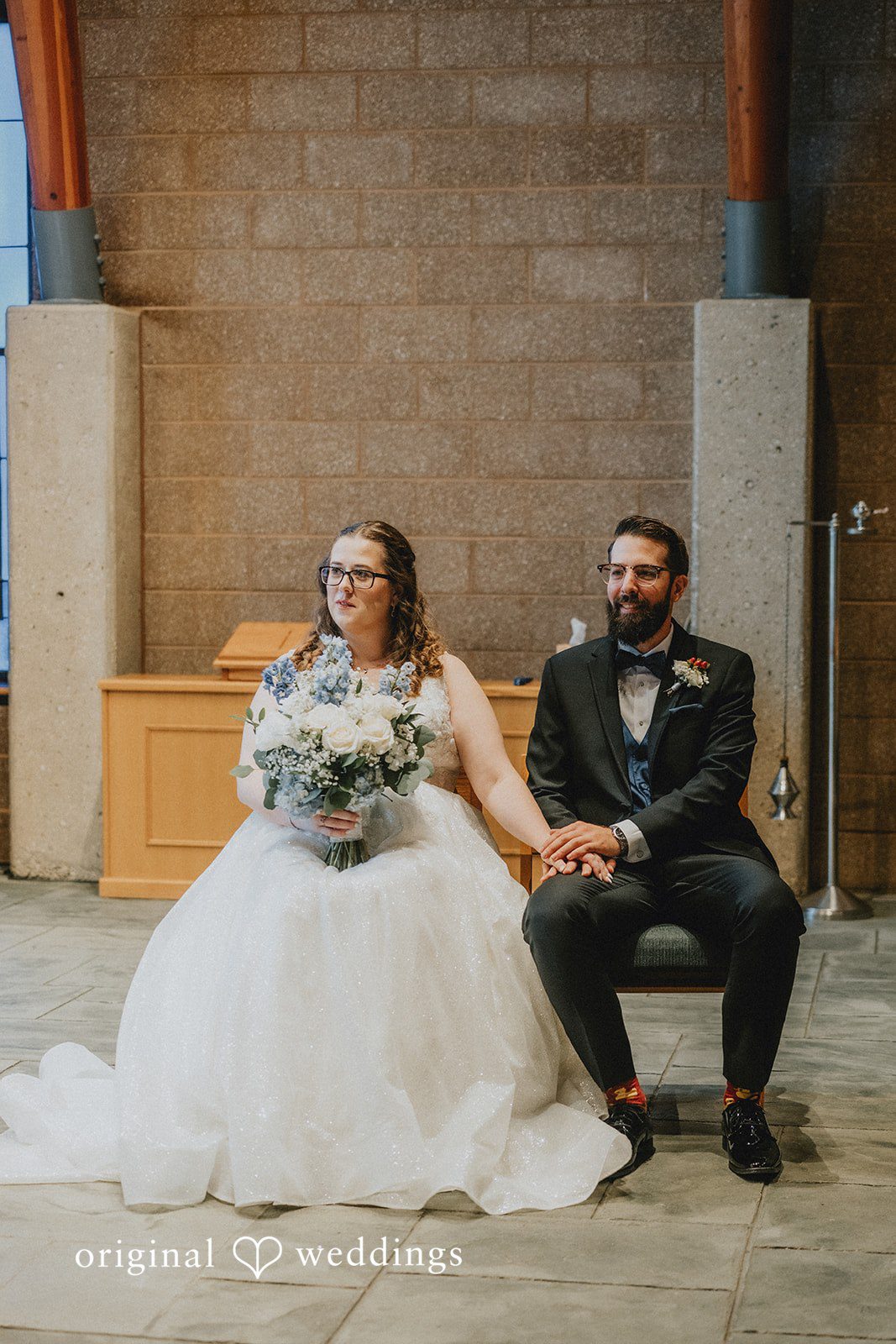Daniel + Amanda A bride holding a bouquet and a groom sitting together on a bench.