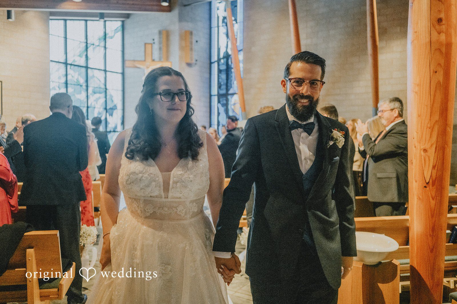 Daniel + Amanda A smiling bride and groom walking down the aisle after their ceremony.