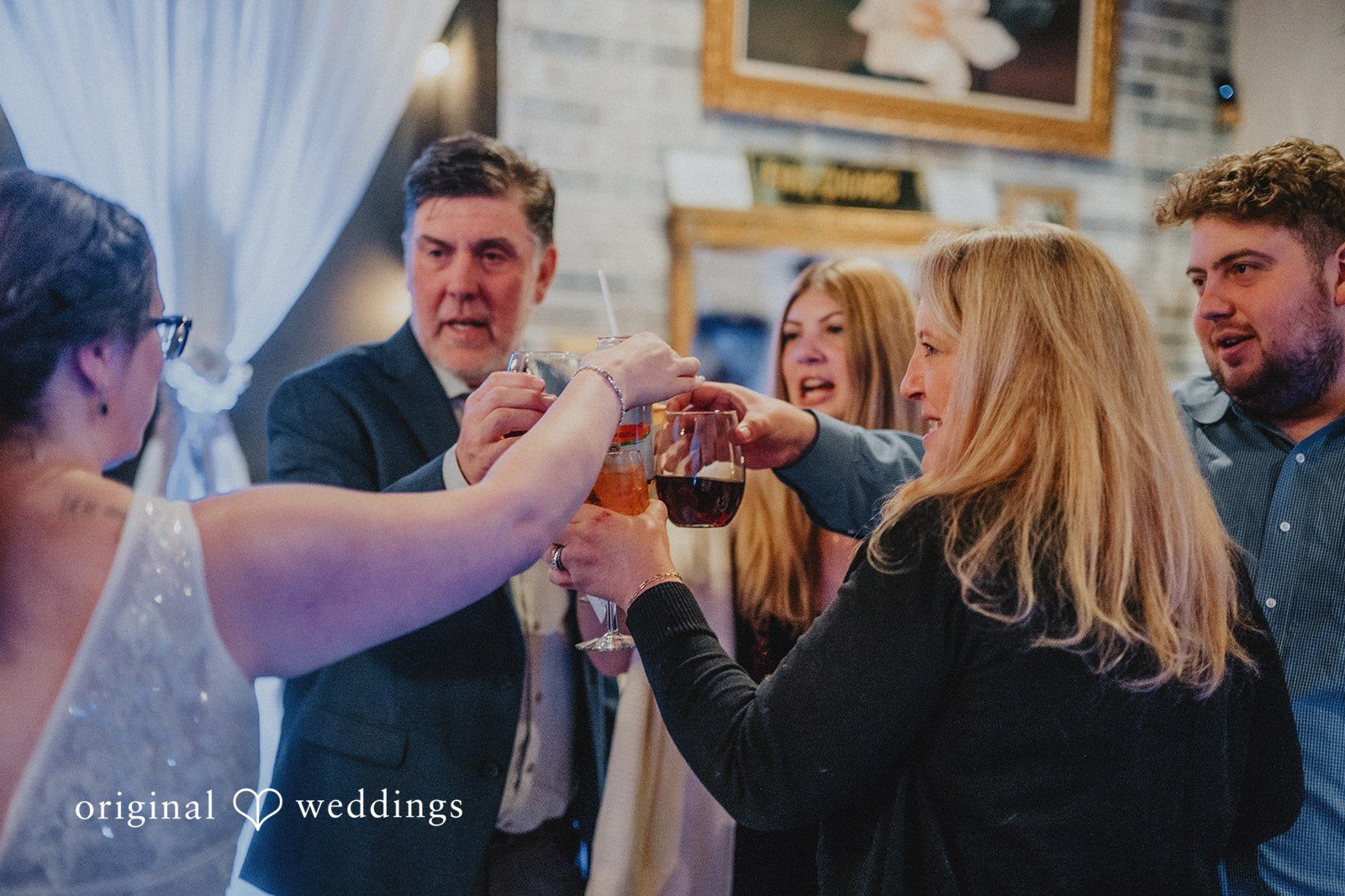 Daniel + Amanda A group of wedding guests raising their glasses together at Magnolia’s Wedding.