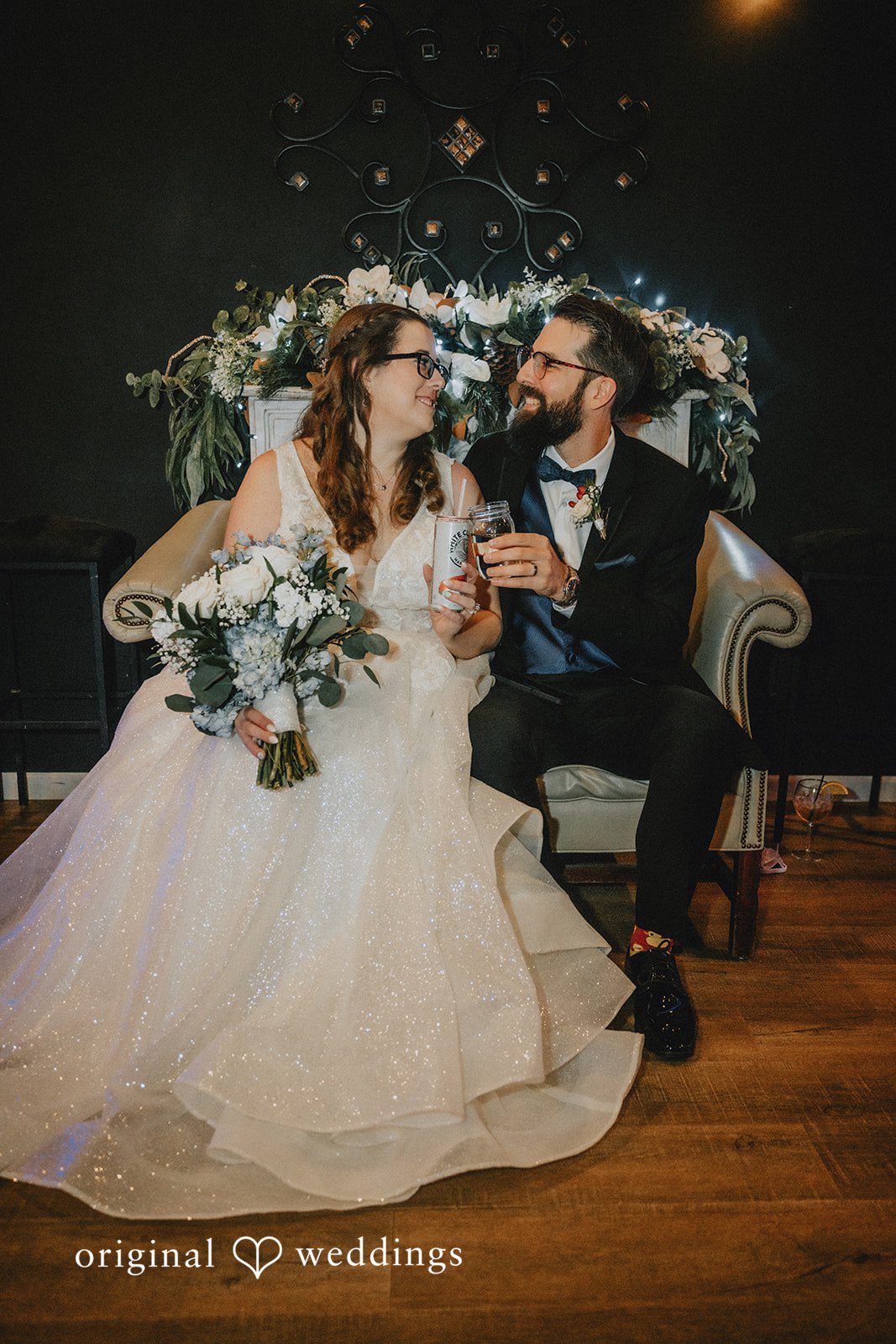 Daniel + Amanda A bride and groom sitting together on a vintage sofa at Magnolia’s Wedding.