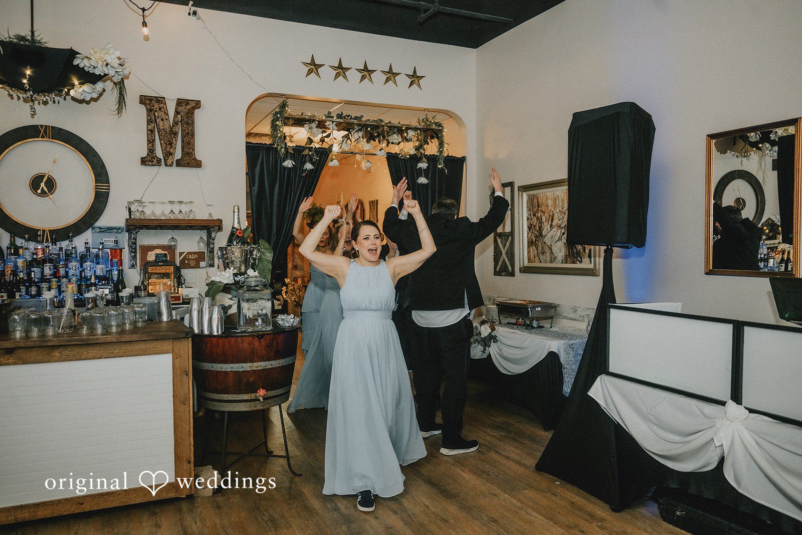 Daniel + Amanda A bridesmaid in a light blue dress dancing with her hands in the air.