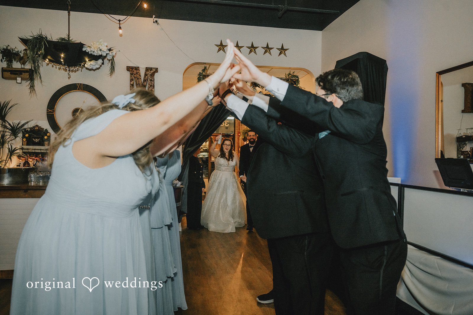 Daniel + Amanda A bride and groom walking under an archway made by their guests' hands.