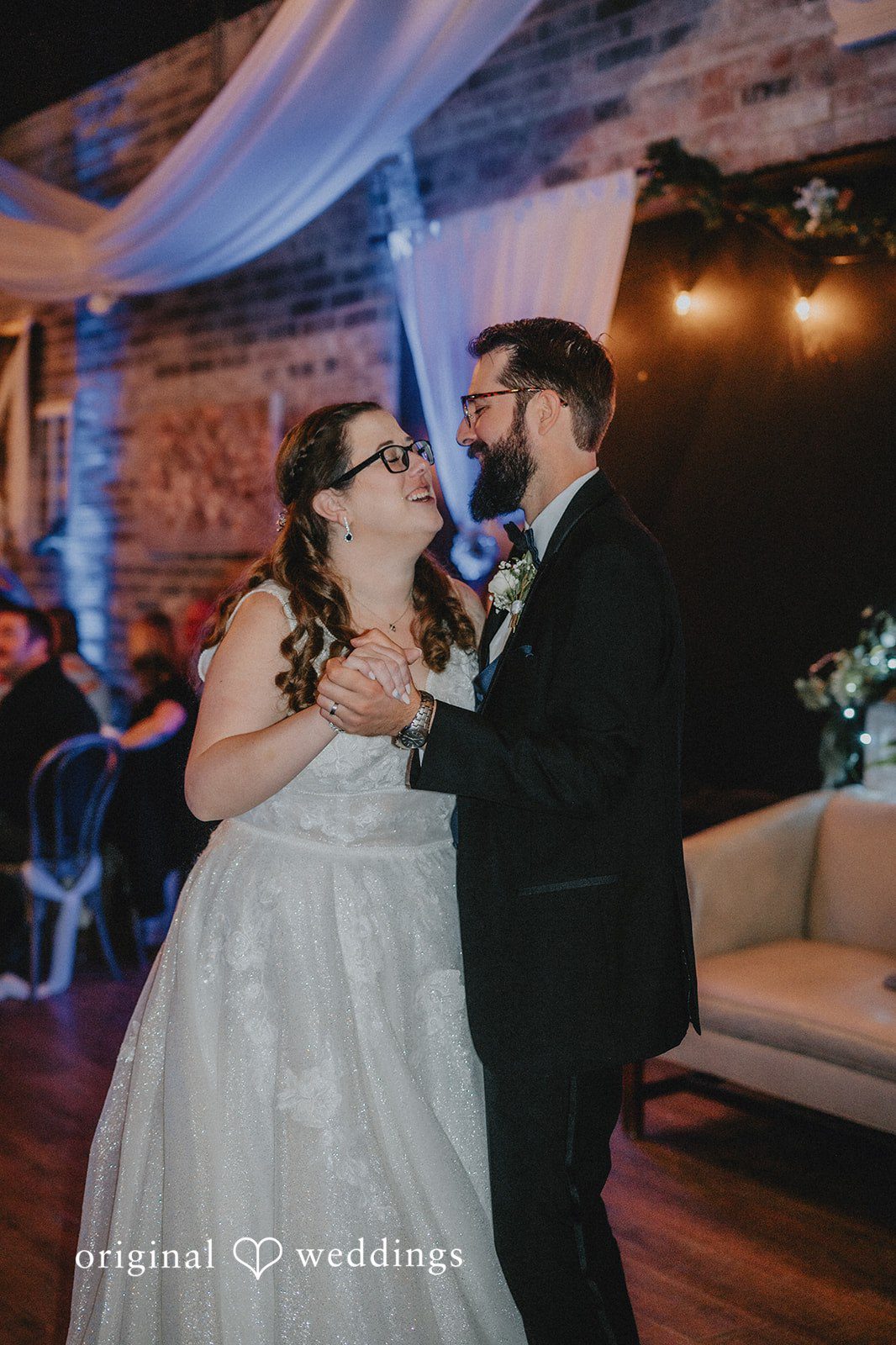 Daniel + Amanda A bride and groom smiling and embracing during their first dance.