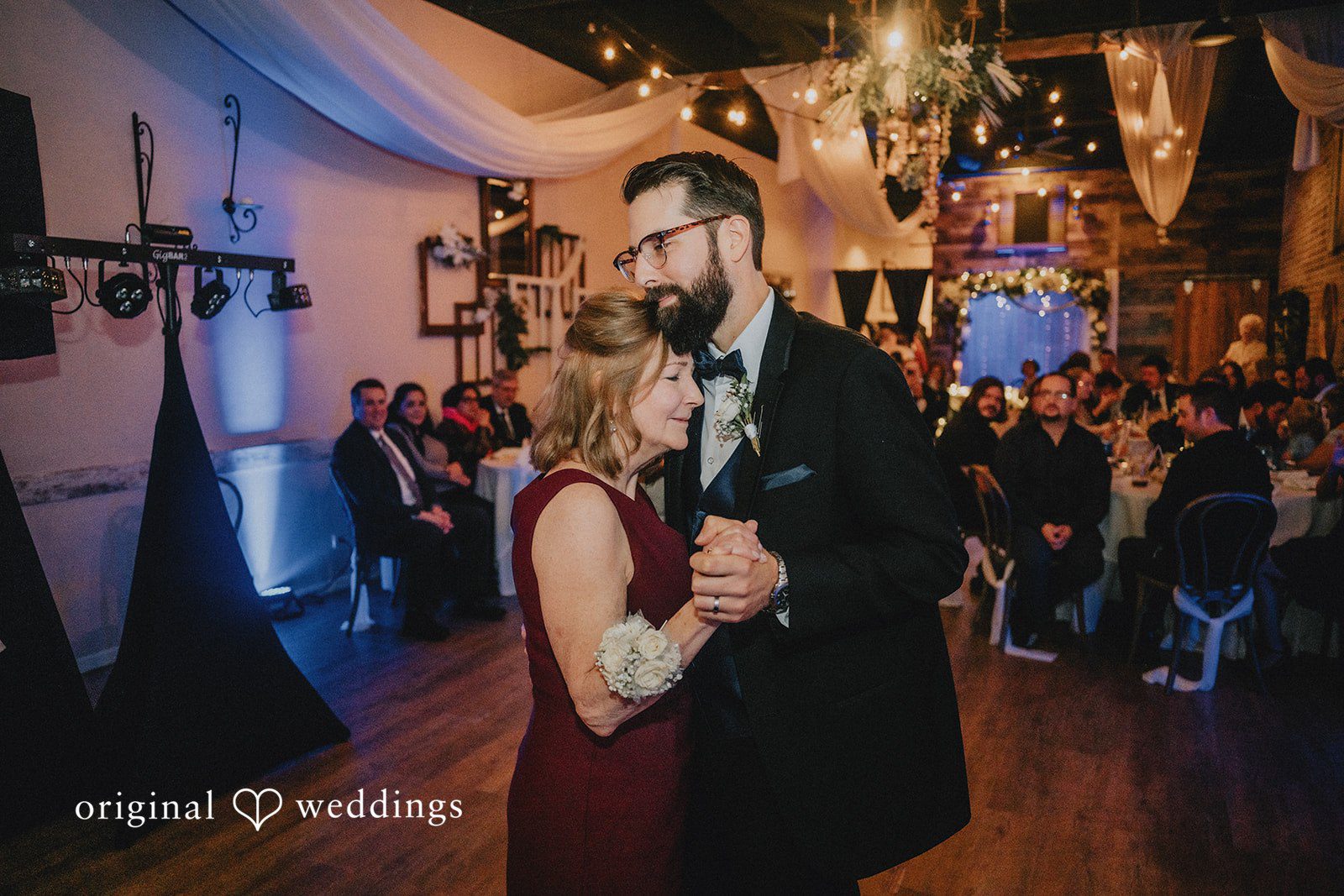 Daniel + Amanda A groom holding a woman in a maroon dress closely.
