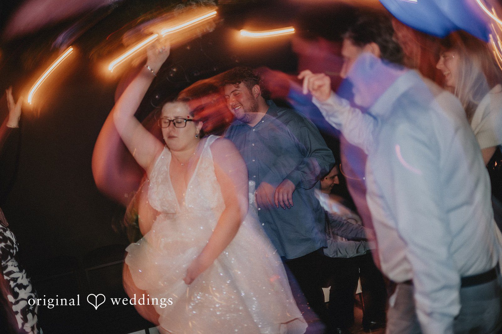 Daniel + Amanda A bride moving with her arm up surrounded by guests at Magnolia’s Wedding.