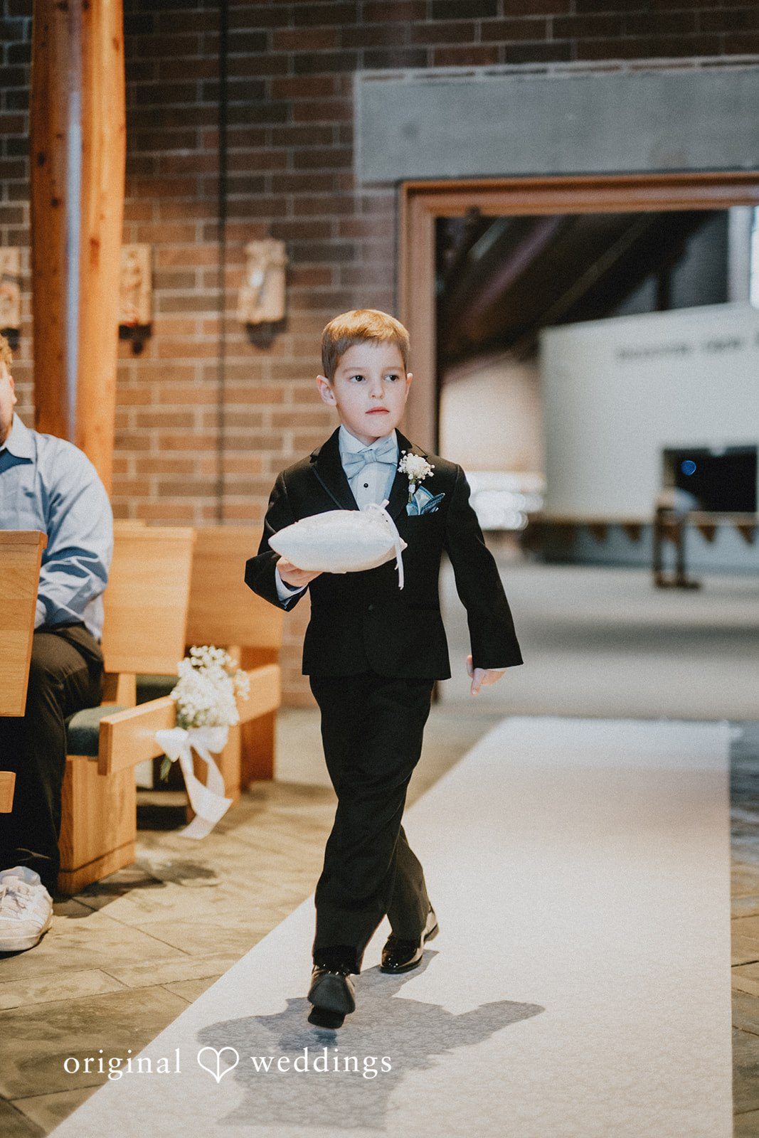 Daniel + Amanda young ring bearer walking down a white aisle runner during a ceremony.