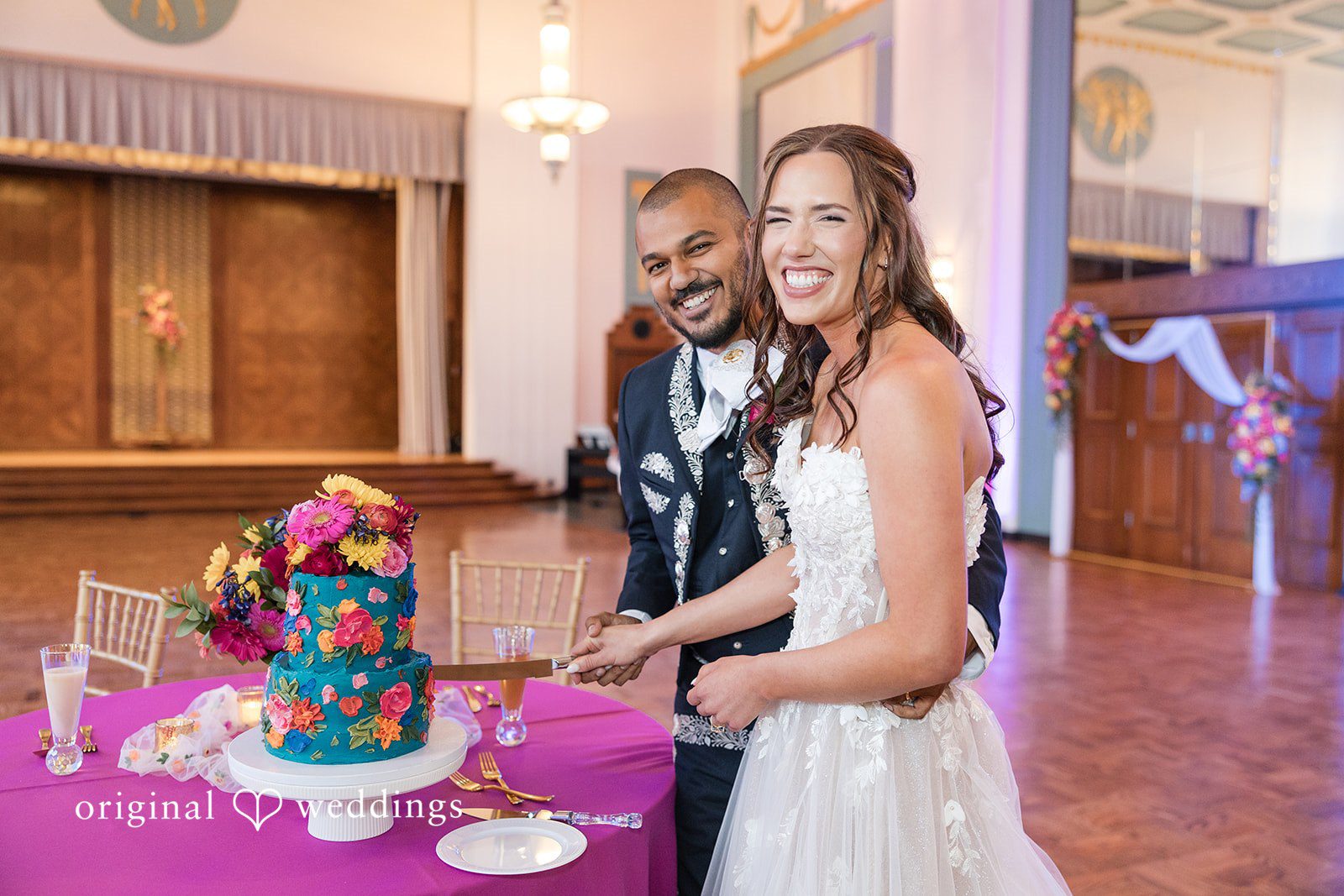 The couple joyfully cuts their wedding cake