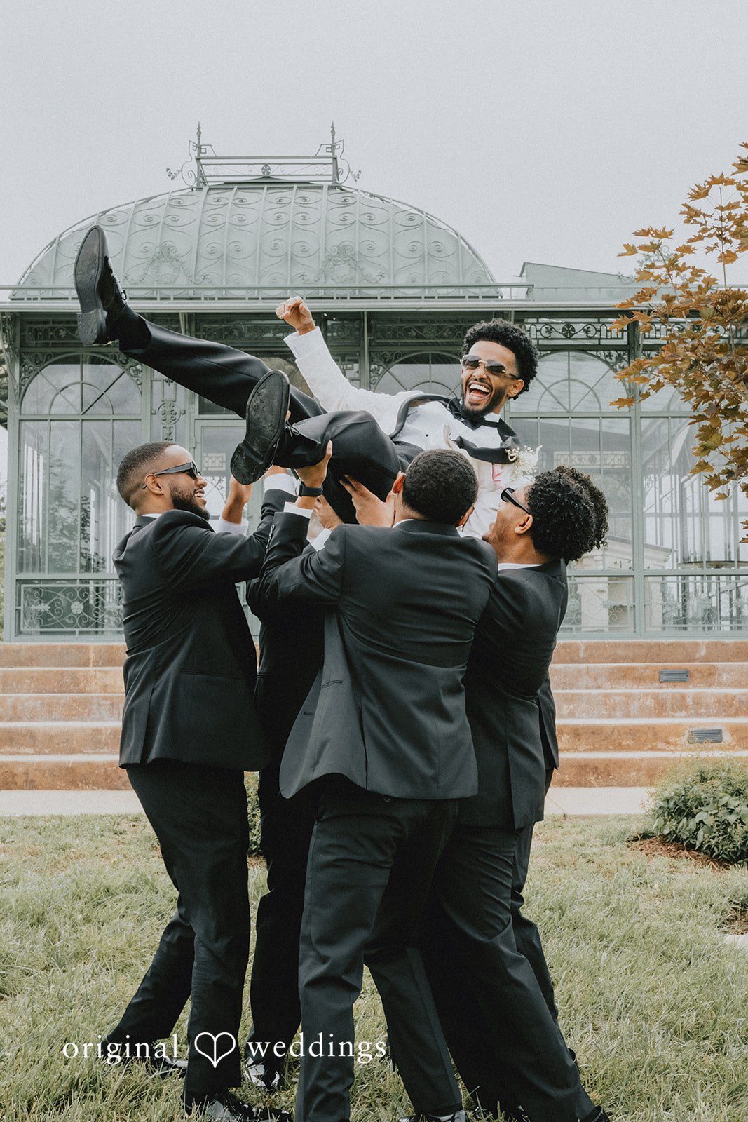 Destiny + Daniel The groomsmen lift the groom up in excitement