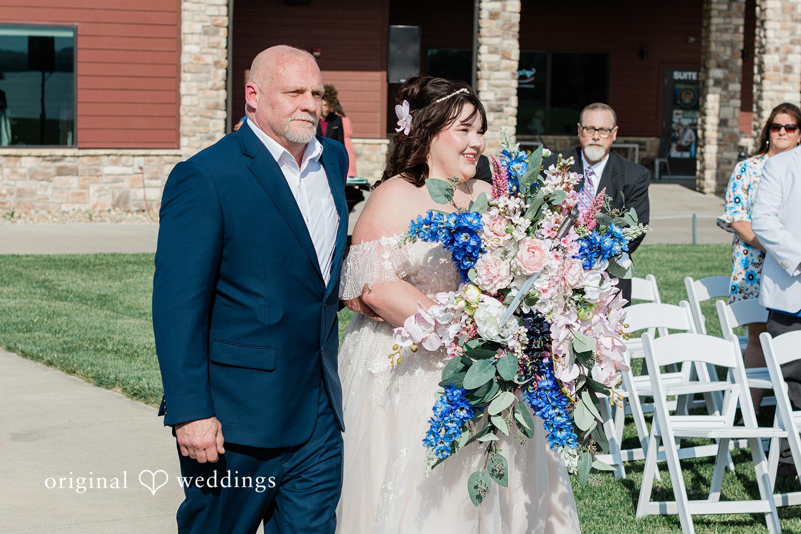 The bride's father escorts the bride down the aisle