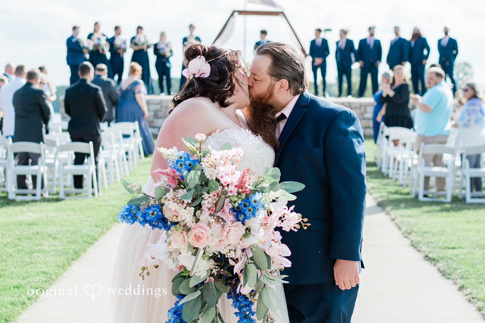 The couple takes a romantic kiss on the aisle