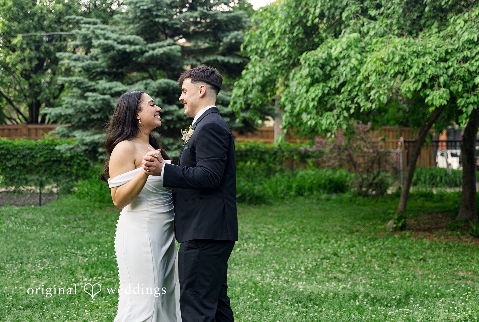 Minneapolis Wedding Photographers capturing a romantic couple smiling at each other while looking into each other’s eyes at Nativity of Our Lord Catholic Church by Original Weddings.