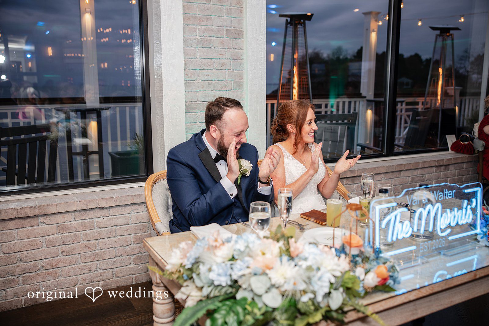 Bride and groom seated together at their reception table