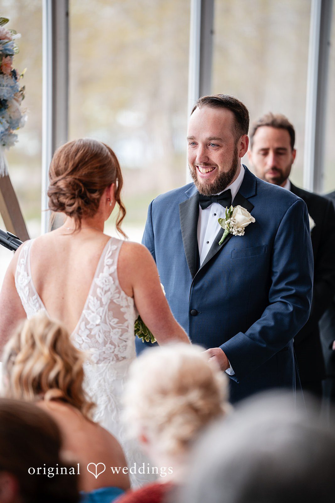 Bride viewed from behind as the groom watches during the ceremony
