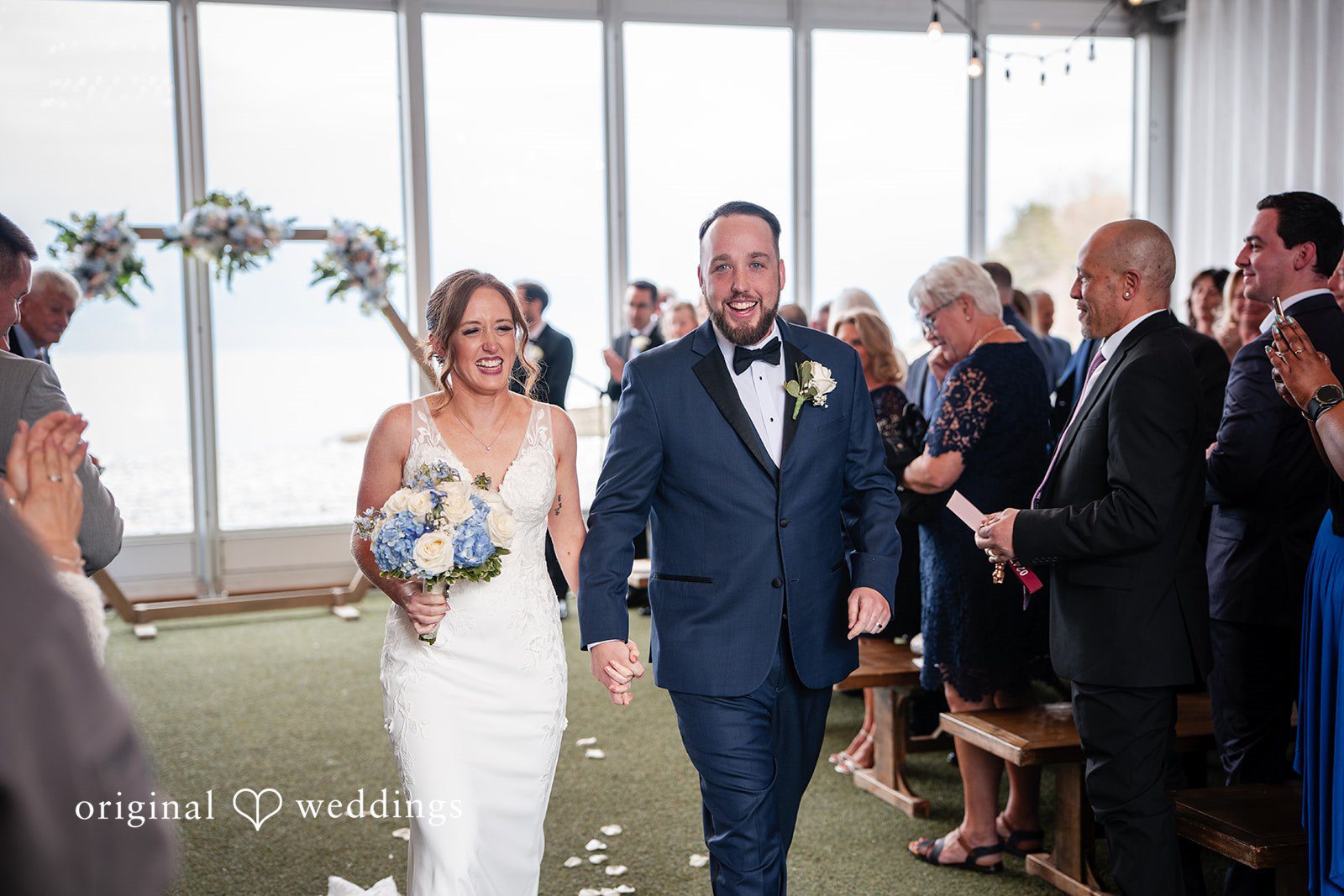 Bride and groom walking hand in hand down the ceremony aisle