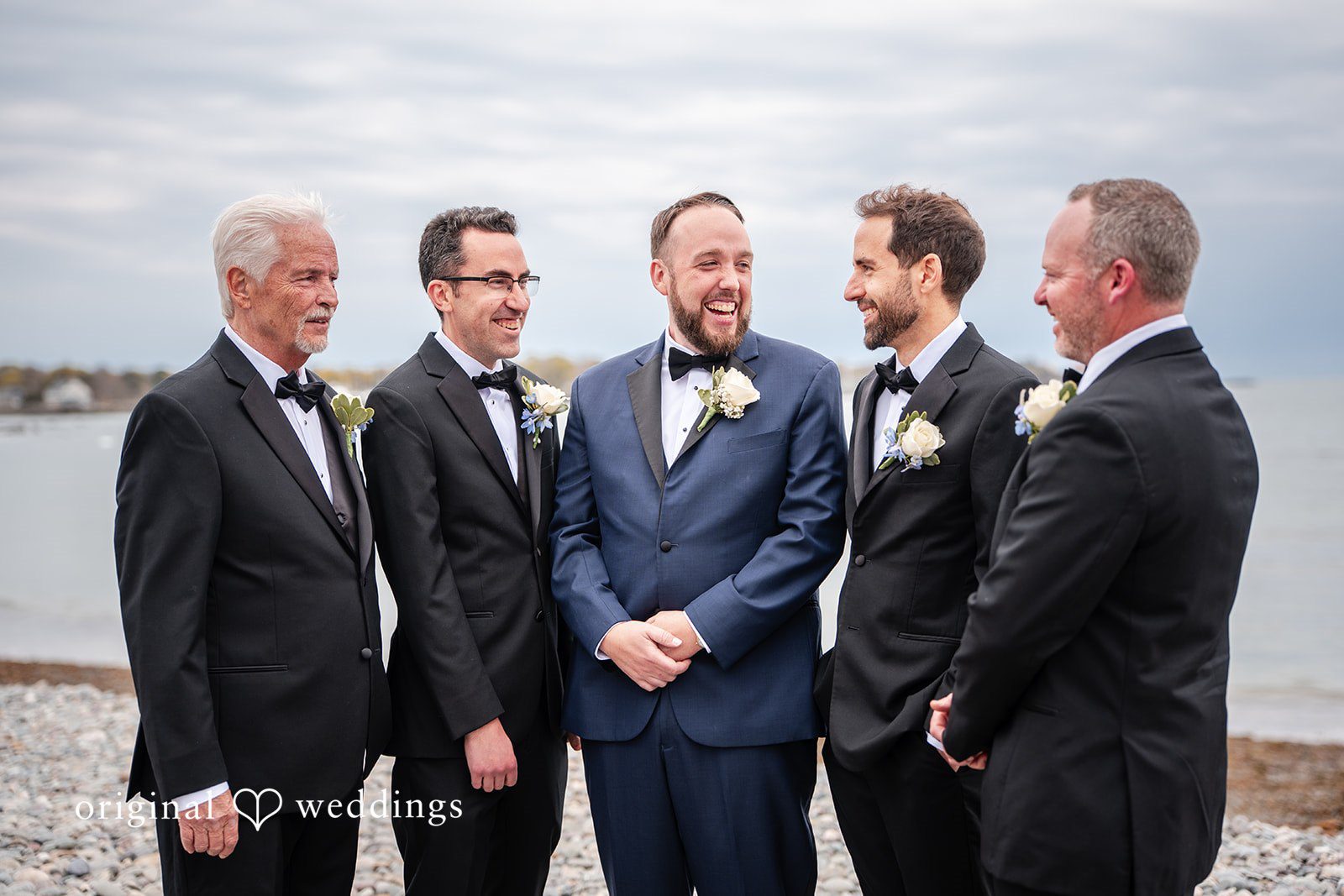 Groom and groomsmen posing together by the oceanfront