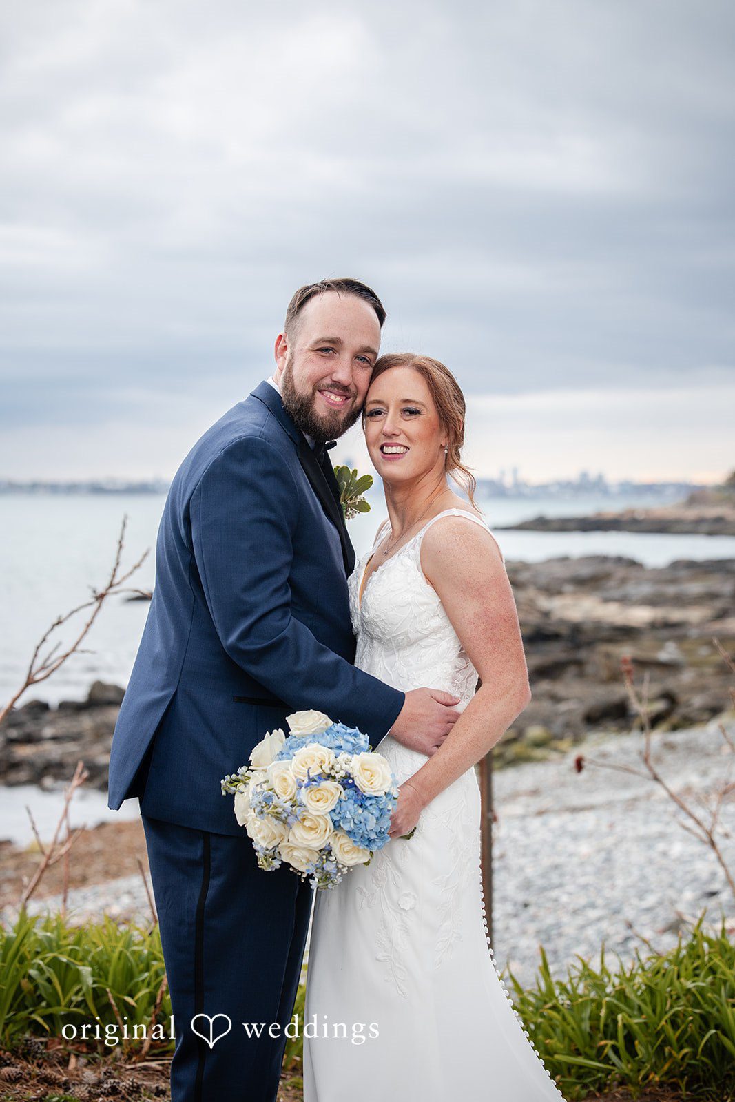 Couple embracing by the sea in a romantic wedding portrait