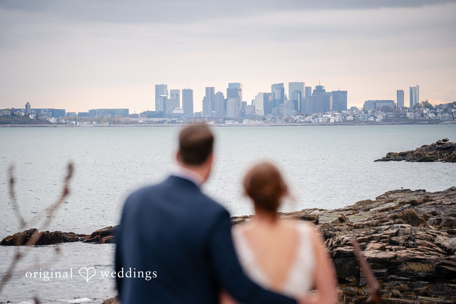 Bride and groom admiring the coastal scenery together from behind