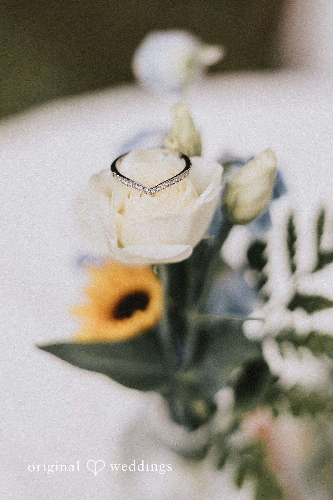 Close up shot of wedding ring placed on a white flower