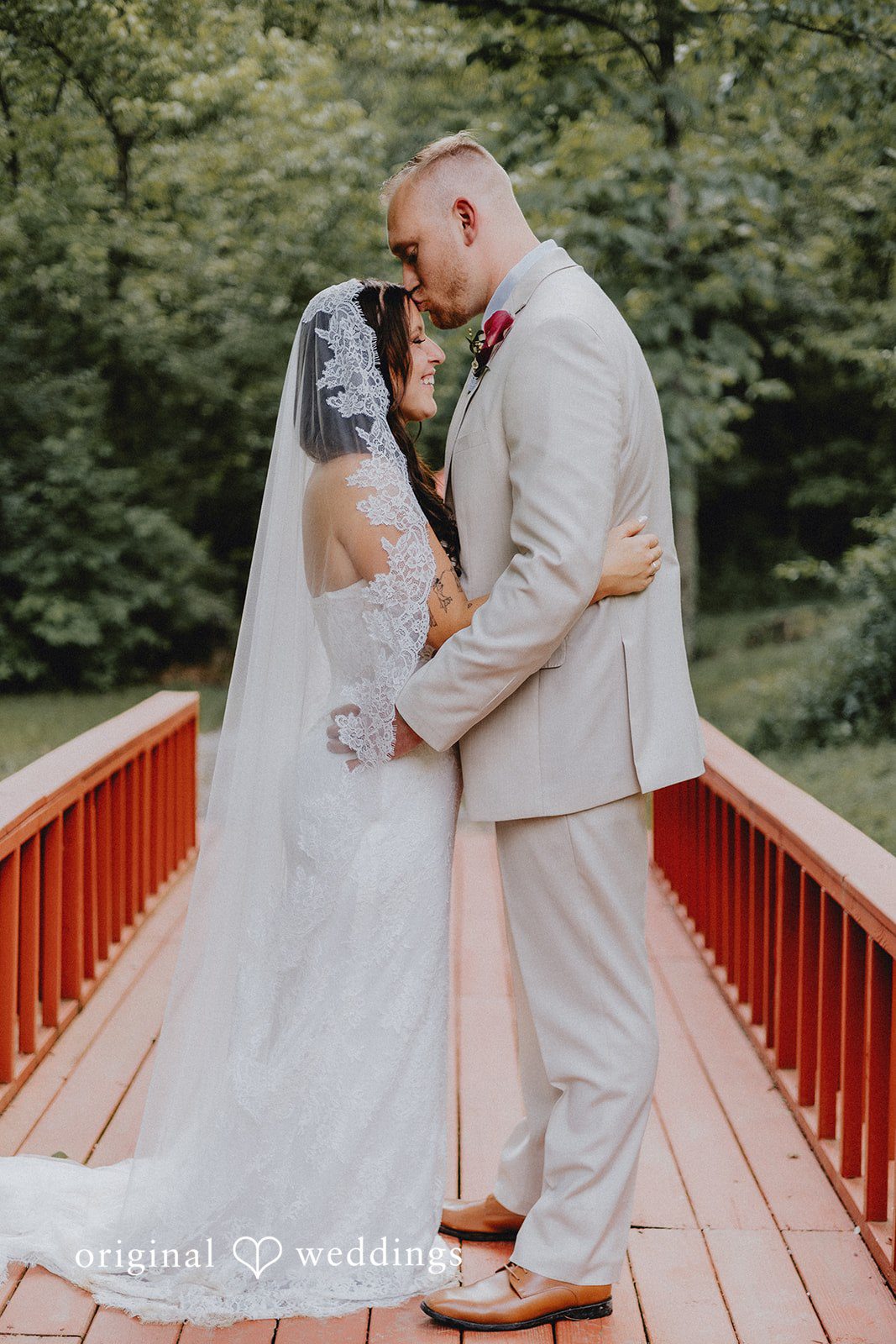 A candid hug and kiss moment of bride and groom