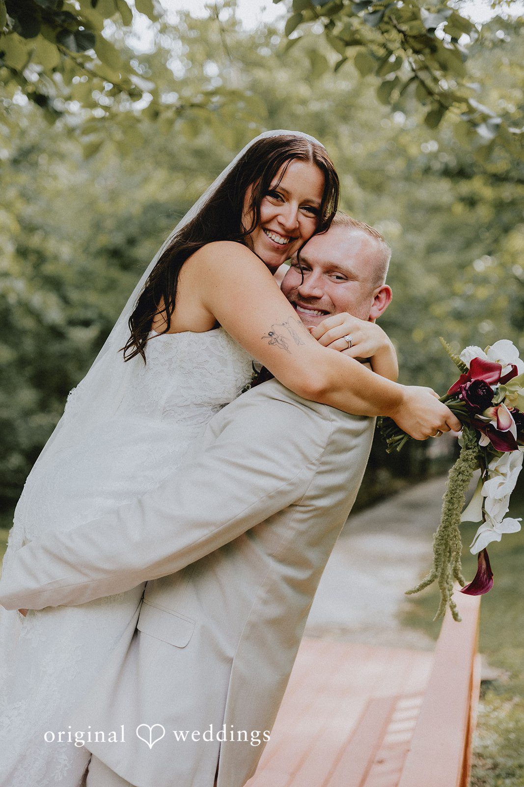 Groom lifting up the bride with love and joy captured by Cincinnati Wedding Photographers from Original Weddings