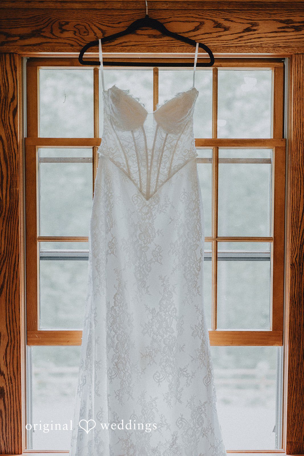 Lovely picture of wedding gown hang across a window