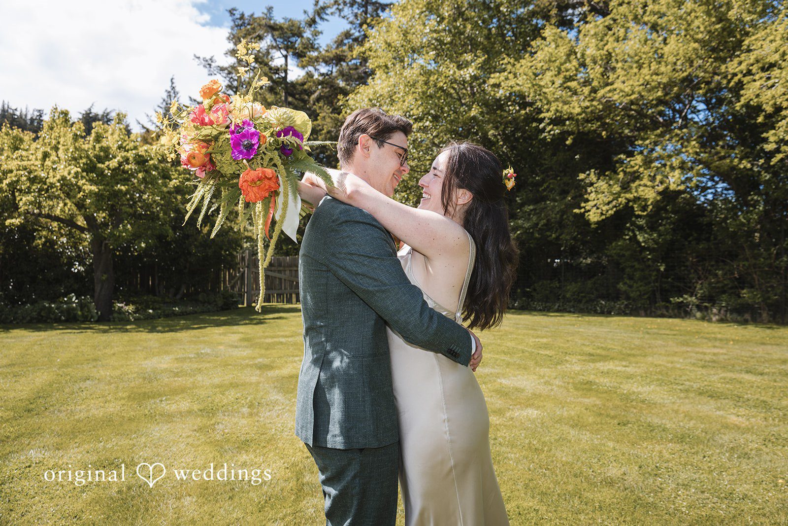Benjamin + Amber The couple shares a joyful embrace on the lawn, smiling at each other while celebrating their wedding