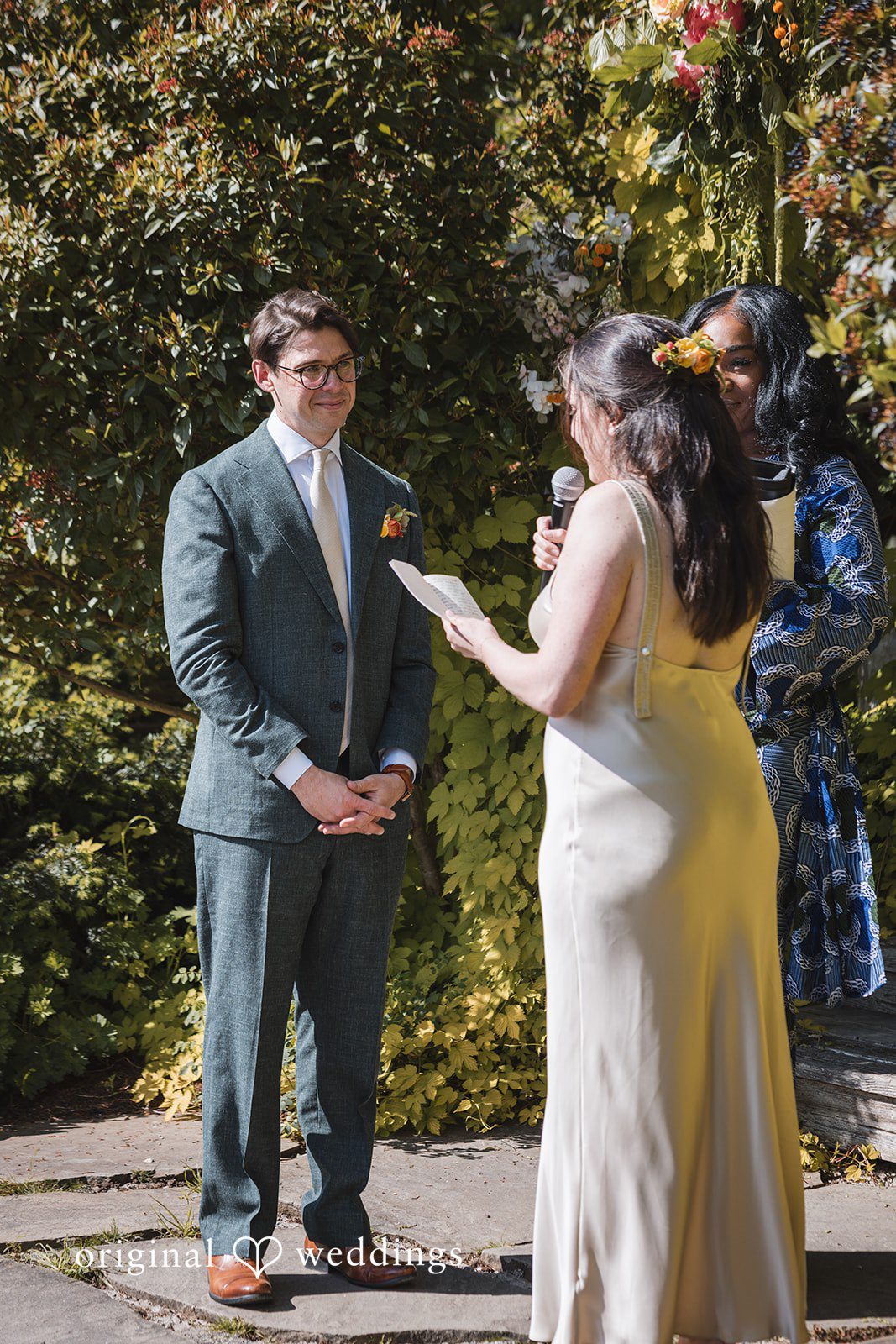 Benjamin + Amber he bride reads heartfelt vows to her partner during an intimate outdoor wedding ceremony at Outlook Inn.